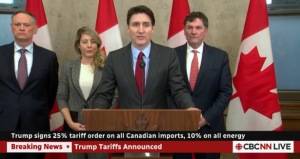 The Prime Minister at a podium on Parliament Hill. Behind him are Foreign Secretary, Finance Minister and Minister for Public Safety